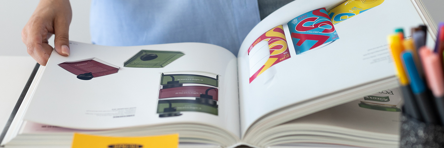 Livro aberto com peças de design editorial